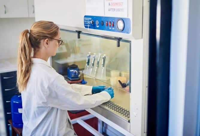 female lab technician working in a ventilation hood