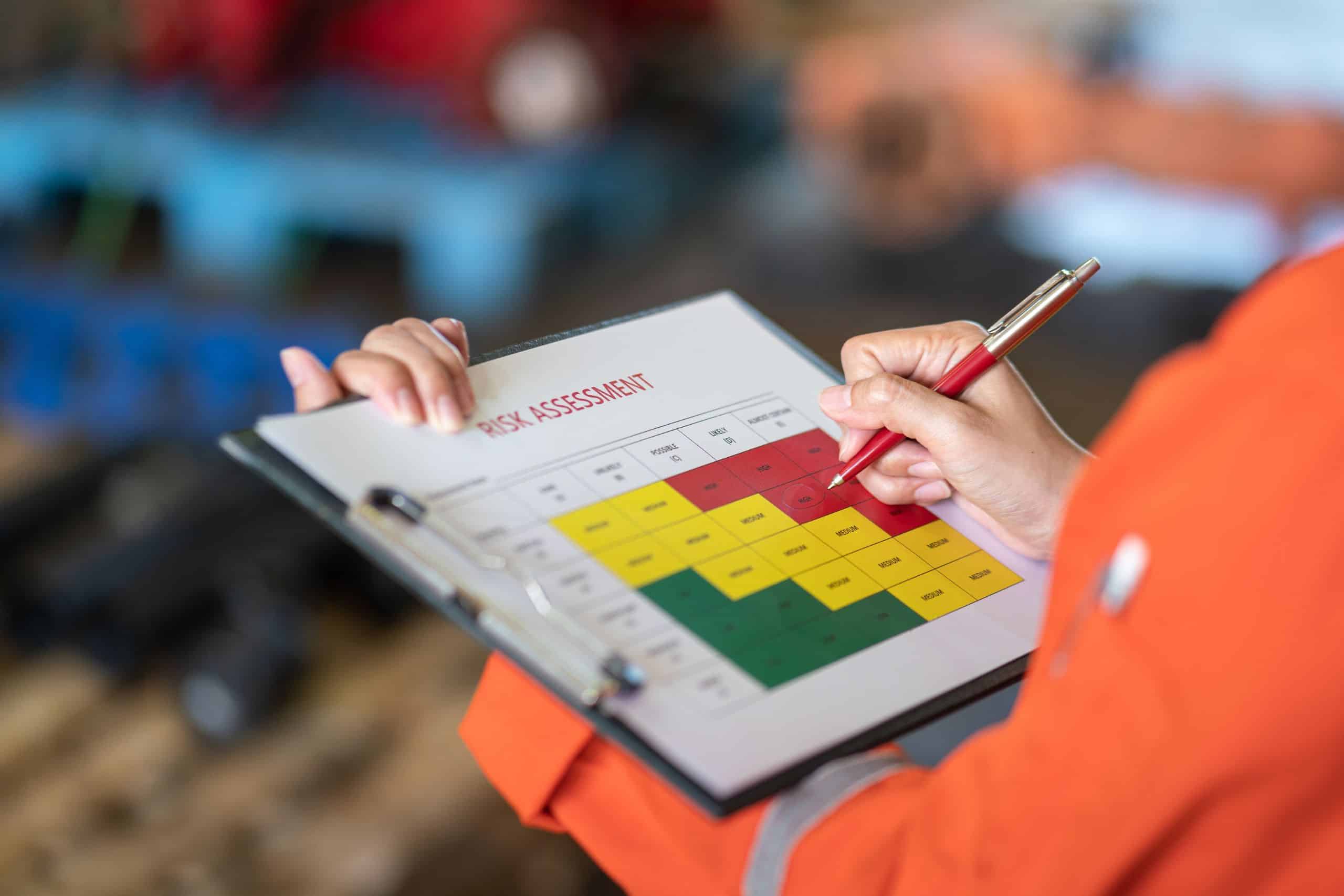 risk assessment performed by a safety consultant in orange work jacket